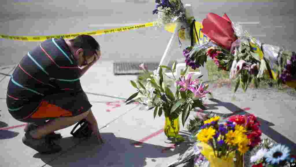 Noah Nicolaisen, de Charleston, Caroline du Sud, s&rsquo;agenouille en mémoire des victimes, jeudi 18 Juin 2015, à l&#39;endroit où un homme a ouvert le feu et tué neuf personnes en réunion de prière à l&#39;intérieur de l&rsquo;église AME Emanuel.