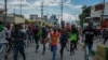 Protesters calling for the resignation of Haitian Prime Minister Ariel Henry run after police fire tear gas to disperse them in the Delmas area of Port-au-Prince, Haiti, Oct. 10, 2022.