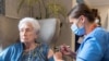 FILE - A nurse administers a COVID-19 vaccine booster to a woman at Victoria Manor Care home, in Edinburgh, Scotland, Britain, on Sept. 5, 2022.
