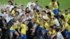 FILE - Brazil's President Jair Bolsonaro and Brazil players celebrate winning the Copa America with the trophy, Maracana Stadium, Rio de Janeiro, July 7, 2019. 