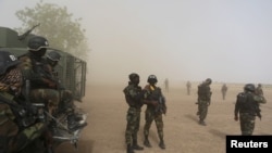 Des soldats camerounais de la Brigade d'intervention déposés par un hélicoptère sous la poussière à Kolofata, Cameroun, le 16 Mars 2016. REUTERS / Joe Penney 