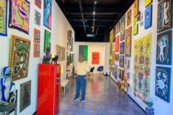 Yon envite nan vernisaj Galerie Monnin, yon nouvo galri d'ar Ayisyen ki fek louvri pot li nan Miami, 1 Dec. 2021. (Photo: Jeanty Augustin Jr / VOA)