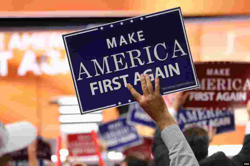 Delegates hold "Make America First Again" posters on the Republican National Convention floor in Cleveland, Ohio, July 20, 2016. (Photo: A. Shaker / VOA)
