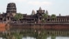 FILE - Tourists walk along the outer wall of Angkor Wat, reflected in its moat in Siem Reap. Russian PM Dmitry Medvedev visited the complex before heading on to Phnom Penh, where he will meet Cambodian leader Hun Sen.