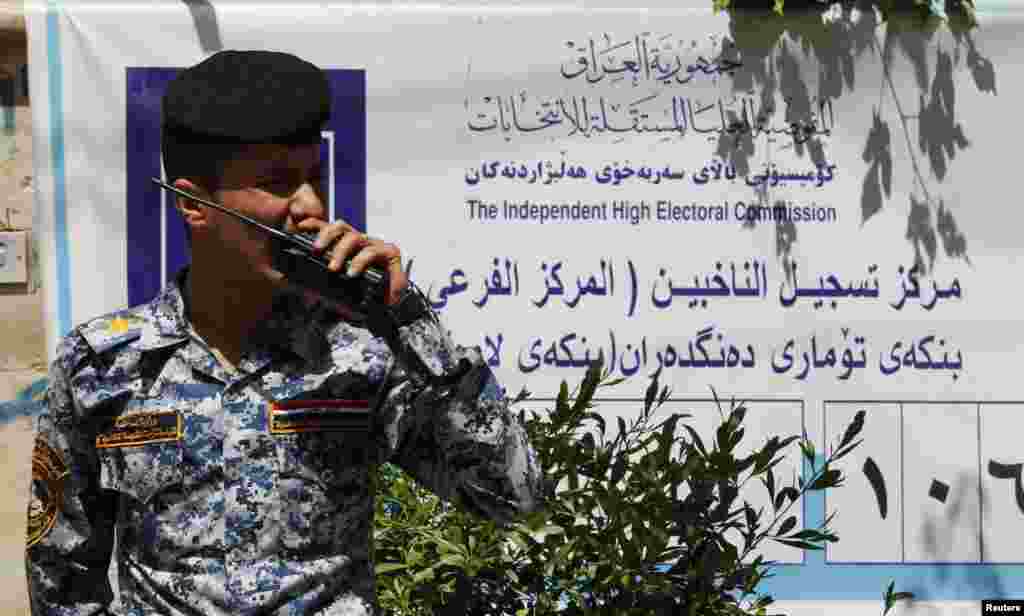 Seorang polisi memberikan instruksi menggunakan "walkie talkie"-nya di sebuah TPS di Baghdad, 19 April 2013. Pemerintah Irak telah memperketat langkah-langkah keamanan di saat negara tengah bersiap menggelar pemilihan pemerintah daerah.