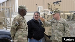 Menhan AS Leon Panetta (tengah) berbincang dengan Mayjen Robert Abrams dan Komandan Pasukan (CSM) Edd Watson (kiri) saat mengunjungi pangkalan udara militer di Kandahar (13/12).