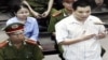 FILE - Nguyen Van Dai, right, testifies in this May 2013 file photo, originally taken from TV footage. The well-known Vietnamese human rights lawyer was arrested on anti-state "propaganda" charges.