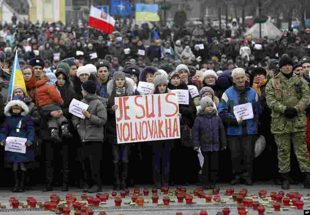 People hold up signs reading "I Am Volnovakha" during a rally at Independence Square in Kyiv in solidarity with the victims of a rocket attack this week that claimed 13 lives on a highway near the eastern town of Volnovakha, Ukraine, Jan. 18, 2015.