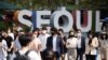 한국의 서울 시내 직장인들이 마스크를 쓴 채 횡단보도를 건너고 있다. 