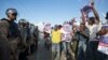 Demonstrators show pictures of ousted president Jean Bertrand-Aristide with former presidential candidate Maryse Narcisse during a march in favor of Senate President Jocelerme Privert for interim president, outside Parliament in Port-au-Prince, Haiti, Feb. 13, 2016.