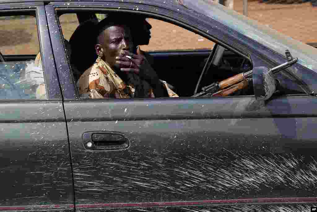 Armed men drive with thousands of Muslim residents from Bangui and Mbaiki fleeing the Central African Republic capital Bangui, Feb. 7, 2014.
