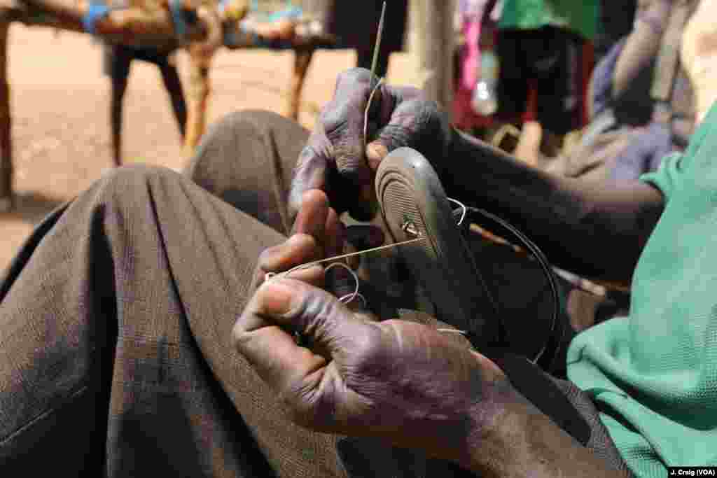 Sixty-year-old refugee from Nimule, South Sudan repairs a fellow refugee’s sandal in exchange for two small mangoes in the Bidibidi refugee settlement in Yumbe, Uganda, April 2.