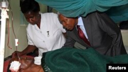 Tanzania's Vice President Mohamed Gharib Bilal consoles a faithful at Mount Meru Hospital, who was injured during an explosion at the new Catholic church, in the northern Tanzanian town of Arusha, May 6, 2013.