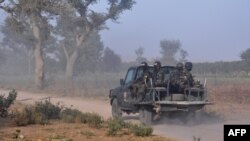 FILE - Members of the Cameroonian Rapid Intervention Force patrol on the outskirt of Mosogo in the far north region of the country where Boko Haram jihadist have been active since 2013, March 21, 2019.