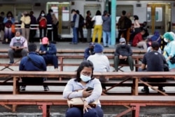 Warga memakai masker saat duduk di stasiun kereta pada jam sibuk, di tengah pandemi COVID-19 di Jakarta, 13 September 2021. (REUTERS/Ajeng Dinar Ulfiana)
