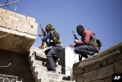 FILE - Militants from the Kurdistan Workers' Party, or PKK, run as they attack Turkish security forces in Nusaydin, Turkey, March 1, 2016. The fight against PKK rebels represents only one front in Turkey's military operations.
