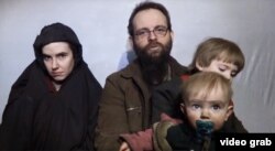 Foto yang diambil dari video yang dirilis pada Desember 2016 oleh Taliban, warga negara AS Caitlan Coleman dan suaminya yang warganegara Kanada, Joshua Boyle membaca pernyataan mendesak Presiden Donald Trump yang saat itu baru terpilih untuk menegosiasikan pembebasan mereka.