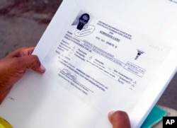 In this picture taken June 9, 2106, Hiweet Berhe Tesfamarian Kidane holds photocopies of documents she told the Associated Press belong to her brother, Medhane Tesfamariam Berhe, during an interview in Oslo.