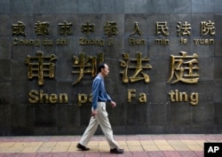 一位男士从四川成都中级法院的审判法庭前走过。成都检察院因为起诉王立军案而“荣记一等功”（资料照）