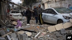 Palestinezët shikojnë dëmet e shkaktuara nga një sulm ajror izraelit në Rafah të Rripit të Gazës më 9 shkurt, 2024/AP