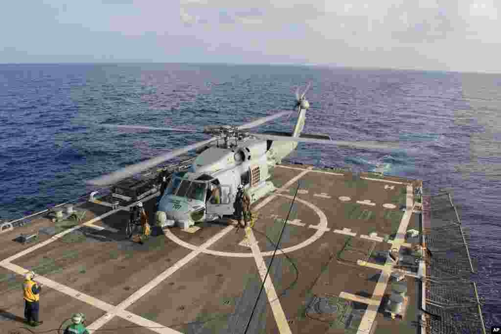 Sebuah helikopter AL AS mendarat di Destroyer USS Pinckney dalam pertukaran kru sebelum kembali melakukan misi pencarian dan penyelamatan untuk pesawat Malaysia yang hilang dengan nomor penerbangan MH370 di Teluk Thailand, 9 Maret 2014. 