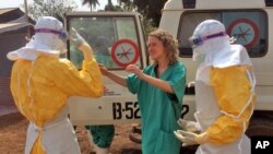 FILE - In this photo provide by MSF, healthcare workers prepare isolation and treatment areas for Ebola in Gueckedou, Guinea, Mar. 28, 2014.