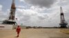 Archivo. Un trabajador de un campo petrolero camina junto a las plataformas de perforación en un pozo petrolero operado por la petrolera estatal venezolana PDVSA, en la rica franja petrolera del Orinoco, el 16 de abril de 2015.