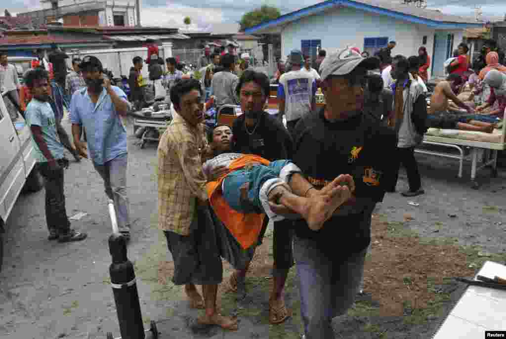 An injured resident is evacuated to the local clinic after a strong earthquake hit in Bener Meriah district in Central Aceh, July 2, 2013.