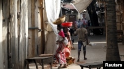 ARCHIVES - Un femme marche à travers un marché déserté après à la suite des manifestations contre la candidature de Pierre Nkurunziza pour un troisième mandat à Bujumbura, le 29 avril 2015. 