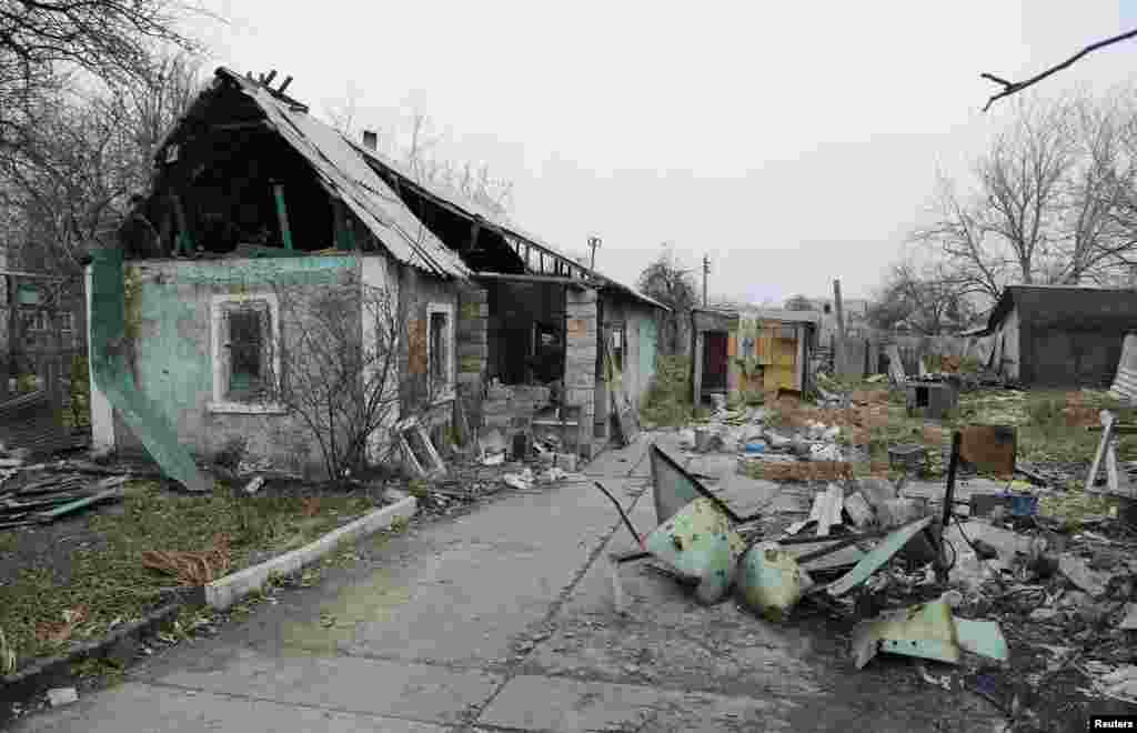 A man enters a destroyed house in the Spartak area near Sergey Prokofiev International Airport in Donetsk, Nov. 18, 2014.