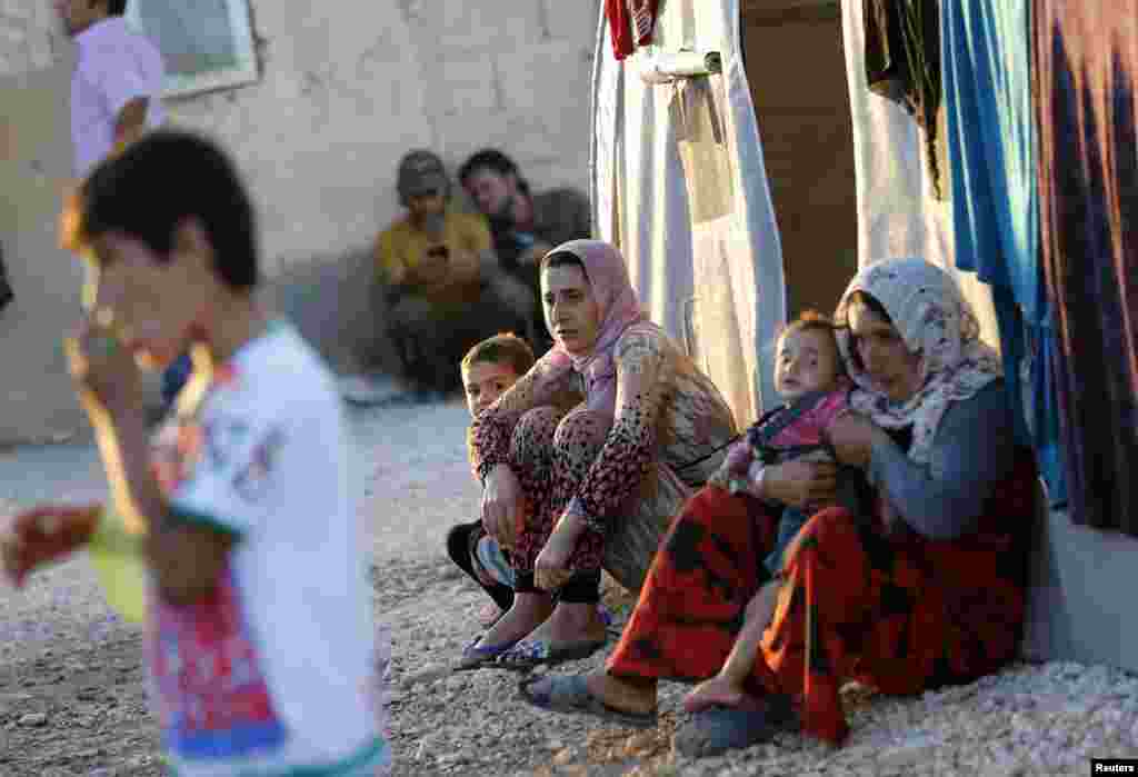 Kurdish refugees from the Syrian town of Kobani sit in a camp in Suruc, Oct. 5, 2014.