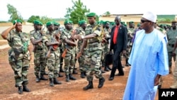 Le président Ibrahim Boubacar Keita passe en revue les troupes à Kati, le 6 août 2015, après avoir rendu visite à des soldats blessés dans une attaque. (AFP PHOTO / Habibou Kouyaté) 