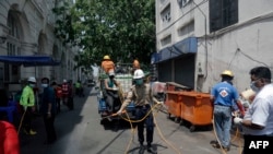 Members of the Myanmar Red Cross Society disinfect a street as a preventive measure 