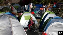 Une réfugiée au milieu des tentes dans un camp à Athènes, 9 avril 2016.
