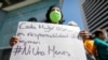 FILE - A woman holds a placard as Venezuelan human rights activists protest to demand the release of 17 women they consider political prisoners, in Caracas, Venezuela, March 8, 2021.