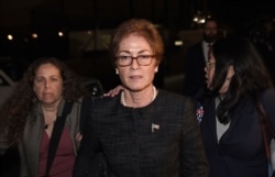 FILE - Former U.S. Ambassador to Ukraine Marie Yovanovitch, center, flanked by lawyers, aides and Capitol police, leaves the Capitol, Oct. 11, 2019, in Washington.