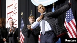 Presiden AS Barack Obama menerima jaket almamater dari Lake Area Technical Institute di Watertown, South Dakota (8/5) usai memberikan pidato kelulusan. (Reuters/Jonathan Ernst)