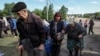 Мешканці Вовчанська та прилеглих сіл чекають на автобуси під час евакуації до Харкова через обстріли Росії, 10-го травня 2024 року. REUTERS/Vyacheslav Madiyevskyy
