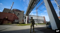 Російський військовослужбовець охороняє територію Запорізької атомної електростанції. Фото зроблено під час поїздки, організованої Міністерством оборони Росії. (AP)