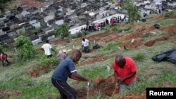 Los sepultureros trabajan en el cementerio municipal mientras familiares y amigos asisten al entierro de Debora Listenberg y sus hijos Heloise, de 2 y Gustavo, de 5 después de que las lluvias torrenciales causaran inundaciones en Petrópolis, Brasil, el 17 de febrero de 2022.
