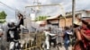 Para migran melemparkan pagar ke arah anggota Garda Nasional dalam aksi protes di luar kantor National Migration Institute (INM) di Tapachula, Meksiko 22 Februari 2022. (REUTERS/Jacob Garcia)
