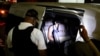 Miembros del Instituto Nacional de Migración (INM) hablan con un migrante detenido durante un allanamiento de las autoridades migratorias y miembros de la Guardia Nacional Mexicana, en Tapachula, México, el 1 de febrero de 2022.