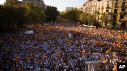 Spain Catalonia Independence: People wave "estelada" flags, that symbolize Catalonia's independence, during a demonstration calling for the independence of Catalonia, in Barcelona, Spain, Sunday, Sept. 11, 2016. 