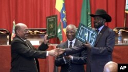 Presiden Sudan Omar al-Bashir (kiri) dan Presiden Sudan Selatan (kanan) berjabat tangan setelah menandatangani perjanjian kerja sama dua negara di Addis Ababa, Ethiopia. (AP/Elias Asmare)