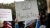 FILE: A demonstrator holds a sign during a protest by New York City Fire Department (FDNY) union members, municipal workers and others, against the city's COVID-19 vaccine mandates on Manhattan's Upper East Side, in New York City, New York, U.S., Oct. 28,