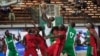 FILE - A player from Kano Pillars, center, in green and white, jumps to make a basket, challenged by Mark Mentors players in red and black, during Nigeria's Final Four in Lagos, Nigeria, Sept. 5, 2013.