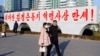 북한 평양 류경체육관 인근에 설치된 김정은 국무위원장 찬양 표어 앞으로 주민들이 지나가고 있다. (자료사진)