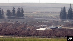 In this Oct. 6, 2019 photo, Turkish forces artillery pieces are seen on their new positions near the border with Syria in Sanliurfa province, Turkey. 