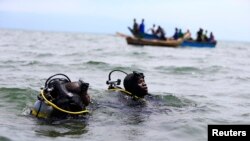 Les membres de l'unité maritime de la police de l'Ouganda participent aux efforts de secours après qu'un bateau transportant des réfugiés principalement congolais a chaviré dans le lac Albert sud-ouest de la capitale ougandaise, Kampala, 23 mars 2014.