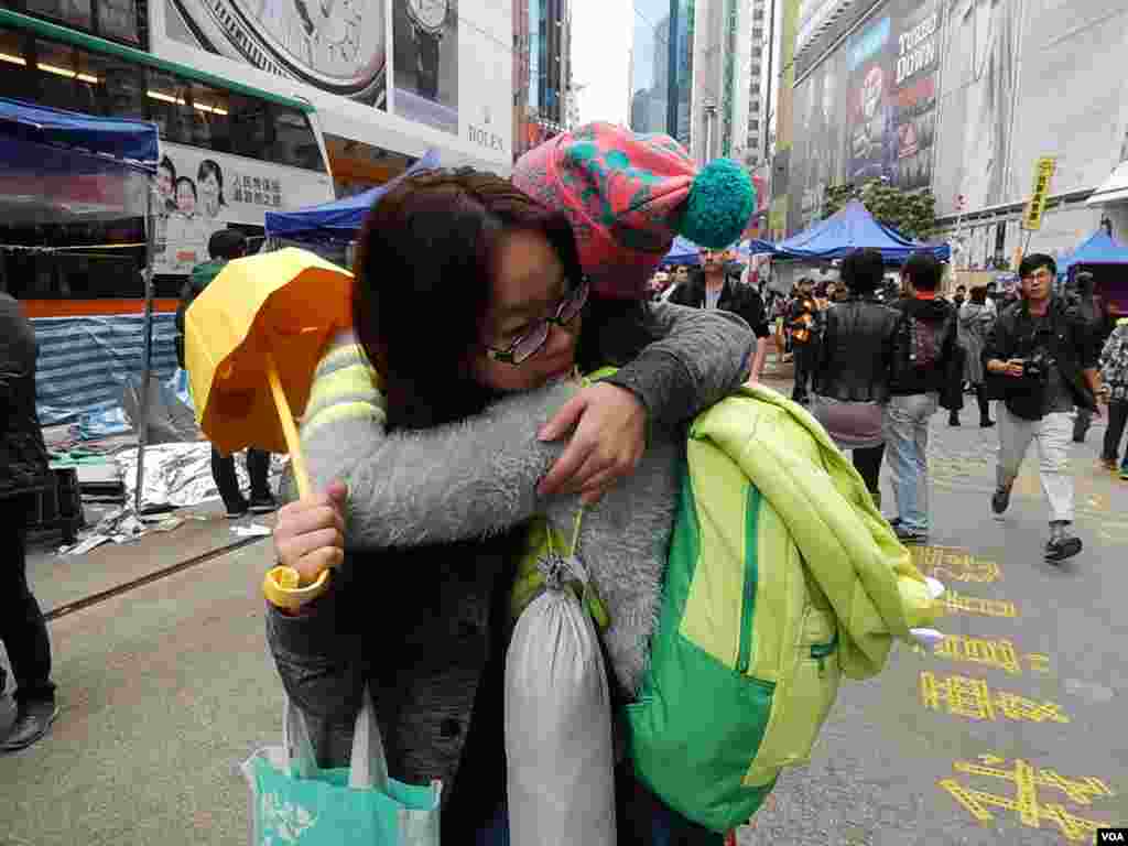 铜锣湾占领区留守者徐小姐(戴眼镜者)在清场前与其他留守者拥抱道别